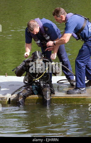 Kollegen aus der Metropolitan Police Marine Support Unit helfen einen Taucher beim Training ausüben. Stockfoto