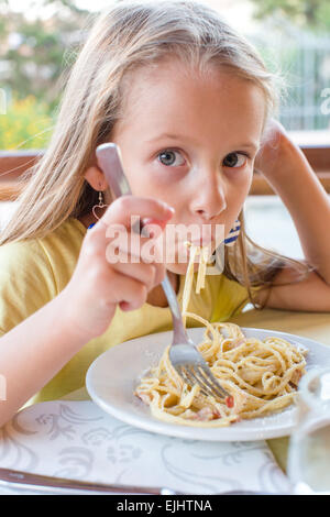 Entzückende kleine Mädchen Spaghetti-Essen im Restaurant im freien Stockfoto