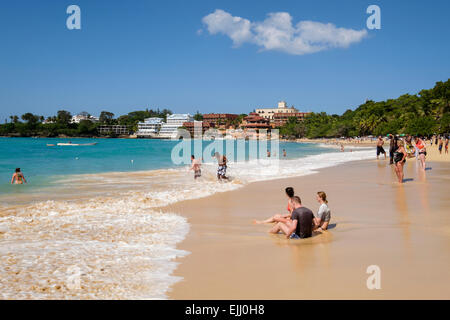 Touristen und Einheimische an einem Sandstrand am Atlantik im Ferienort Sosua, Dominikanische Republik, Karibik Stockfoto