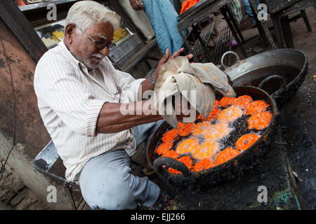 Man drückte einen Beutel mit Gemisch zu braten und Kochen Jalebi und Imarti in einer großen Pfanne in Dhule Stockfoto