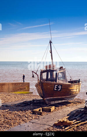 Ein hölzernes Fischerboot am Strand in Sidmouth, Devon, England, UK oben geschleppt. Stockfoto