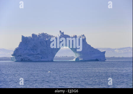 Eisberg mit einem Bogen schwebend in der Disko-Bucht. Diese Eisberge sind vom Jakobshavn Gletscher gekalbt. Stockfoto