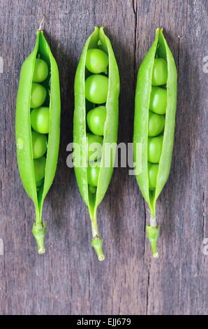 Grüne Erbsen auf hölzernen Hintergrund Stockfoto