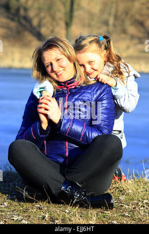 Mutter und Tochter umarmen und Lächeln im zeitigen Frühjahr Stockfoto