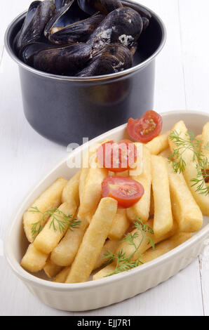 Gekochte Muscheln und Pommes frites in eine Schüssel mit Tomate und Dill, belgische Gericht Stockfoto