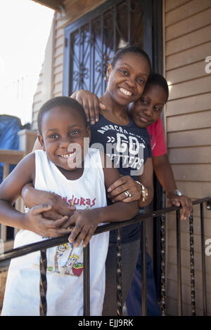 Porträt der Mutter und zwei Söhne auf ihrer Veranda in Brooklyn, New York. Stockfoto