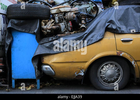 Bangkok, Thailand. 25. Februar 2015. Altes Auto parkte auf der Straße mit einer Menge von gebrauchten Autoteilen auf. Chengkon ist ein Bereich innerhalb Talad Noi in der Chinatown Bezirk von Bangkok, wo rauh aussehende Männer verbringen den ganzen Tag, in den Schlamm arbeiten fast ohne Schutz Hände. Dies ist eines der lukrativen Unternehmen in Thailand, die meisten Autos sind japanische Marke aus Japan importieren, wenn sie zu alt, oder in Thailand gestohlen wurden, sie zerlegen, Reparatur, Neueinbau und Re über Thailand zu verkaufen, oder exportieren Sie in Ländern wie Pakistan, Bangladesh, Afrika. © Guillaume Payen/ZUMA Draht/Alamy Live-Nachrichten Stockfoto