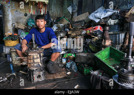 Bangkok, Thailand. 25. Februar 2015. Ein Arbeiter ist in seinem Laden, umgeben von einer Menge von Junk-e-abgebildet. Chengkon ist ein Bereich innerhalb Talad Noi in der Chinatown Bezirk von Bangkok, wo rauh aussehende Männer verbringen den ganzen Tag, in den Schlamm arbeiten fast ohne Schutz Hände. Dies ist eines der lukrativen Unternehmen in Thailand, die meisten Autos sind japanische Marke aus Japan importieren, wenn sie zu alt, oder in Thailand gestohlen wurden, sie zerlegen, Reparatur, Neueinbau und Re über Thailand zu verkaufen, oder exportieren Sie in Ländern wie Pakistan, Bangladesh, Afrika. © Guillaume Payen/ZUMA Draht/Alamy Live-Nachrichten Stockfoto