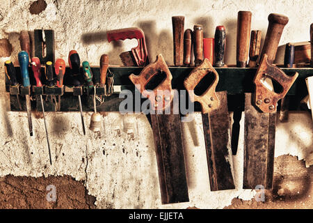 Eingestellt von alten Handsägen aus einem Regal an der Wand hängen Stockfoto