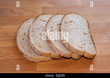 Vier Scheiben geschnitten Stück Vollkornbrot auf Holz braun. Stockfoto