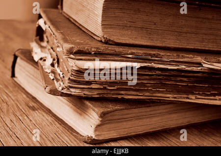 Nahaufnahme von einem Haufen von abgenutzten alten Bücher auf einem rustikalen Holztisch, in Sepia Tönung Stockfoto