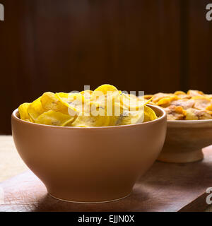 Schalen mit salzig (vorne) und süß (hinten) Wegerich chips, ein beliebter Snack in Südamerika mit Tageslicht fotografiert Stockfoto