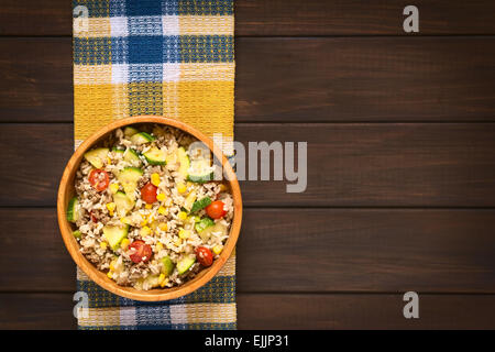 Overhead Schuss Reisgericht mit Hackfleisch und Gemüse (Mais, Cherry Tomaten, Zucchini, Zwiebel) in Holzschale Stockfoto