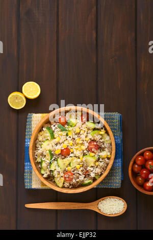 Overhead Schuss Reisgericht mit Hackfleisch und Gemüse (Mais, Cherry Tomaten, Zucchini, Zwiebel) in Holzschale Stockfoto