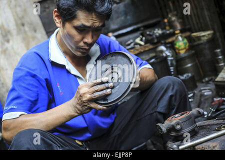 Bangkok, Bangkok, Thailand. 25. Februar 2015. Ein Mann reparieren einen Teil einer Auto-Motor-Front seines Ladens. Chengkon ist ein Bereich innerhalb Talad Noi in der Chinatown Bezirk von Bangkok, wo rauh aussehende Männer verbringen den ganzen Tag, in den Schlamm arbeiten fast ohne Schutz Hände. Dies ist eines der lukrativen Unternehmen in Thailand, die meisten Autos sind japanische Marke aus Japan importieren, wenn sie zu alt, oder in Thailand gestohlen wurden, sie zerlegen, Reparatur, Neueinbau und Re über Thailand zu verkaufen, oder exportieren Sie in Ländern wie Pakistan, Bangladesh, Afrika. © Guillaume Payen/ZUMA Draht/Alamy Live-Nachrichten Stockfoto