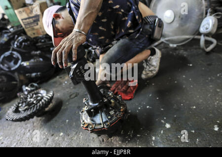 Bangkok, Bangkok, Thailand. 25. Februar 2015. Ein Mann hält einen Teil eines Automotors in seinem Geschäft. Chengkon ist ein Bereich innerhalb Talad Noi in der Chinatown Bezirk von Bangkok, wo rauh aussehende Männer verbringen den ganzen Tag, in den Schlamm arbeiten fast ohne Schutz Hände. Dies ist eines der lukrativen Unternehmen in Thailand, die meisten Autos sind japanische Marke aus Japan importieren, wenn sie zu alt, oder in Thailand gestohlen wurden, sie zerlegen, Reparatur, Neueinbau und Re über Thailand zu verkaufen, oder exportieren Sie in Ländern wie Pakistan, Bangladesh, Afrika. © Guillaume Payen/ZUMA Draht/Alamy Live-Nachrichten Stockfoto