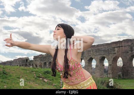 Bauchtänzerin mit Ruinen der alten römischen Aquädukte im Hintergrund Stockfoto