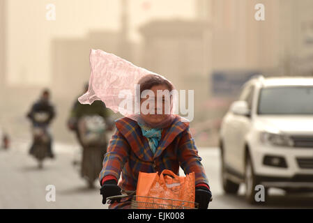 Tianjin, China. 28. März 2015. Eine Frau fährt in staubigen Wind mit Schleier auf Gesicht auf einer Straße in Tianjin, Nord-China, 28. März 2015. Teil von Tianjin erhielt staubige Wetter am Samstag. Bildnachweis: Yue Yuewei/Xinhua/Alamy Live-Nachrichten Stockfoto