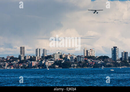 Sydney, Australien. Ein kleines Wasserflugzeug fliegt über Sydney Harbour. Stockfoto