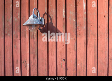 Rustikale Lampe Metall auf roten Holzwand mit Textfreiraum. Stockfoto