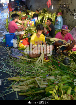 Manila, Philippinen. 28. März 2015. Durch einen Zeitplan für die morgigen Palmsonntag für den ersten Tag der kommenden Karwoche im Land eilen die Gruppe von Palm-Hersteller ihre Ware verdienen viel besseren Preis für ihren Familien-Haushalt benötigt. Genannte Gruppe platziert neben den Baclaran Kirche von der genannten Stadt, die man von den geplanten palm Segnungen aus der Stadt. Bildnachweis: Wilfredo Geschrei/Pacific Press/Alamy Live-Nachrichten Stockfoto