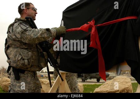 Sgt. Major James Pippin nutzt seine Kampfmesser, um das Band zu schneiden, enthüllt die Zeichen mit dem neuen Namen der Landezone auf Forward Operating Base Marez, in Mosul, Irak, 20. März 2009. Die Landezone wurde umbenannt, zu Ehren des Oberstleutnant Gary Derby und vier Mitglieder seiner persönlichen Sicherheit Detail, die im Februar zu einem Selbstmord Fahrzeug getragen improvisierte explosive Gerät verloren gingen.        Landing Zone benannt nach gefallenen Bataillonskommandeur www.dvidshub.net/?script=news/news show.php&amp;id=32096 Stockfoto