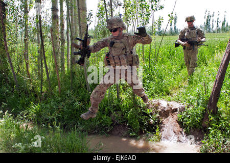 Staff Sgt Ray Perez-Rosa, Infanterist mit Truppe C, 6. Staffel, 8. Kavallerie-Regiment, springt über einen wassergefüllten Graben während auf einer Fuß-Patrouille, indirektes Feuer in der Nähe von Combat Outpost Baraki Barak, 21. Mai 2013 entgegenzuwirken. Mitglieder der Truppe C Patrol führen Patrouillen in ihren Bemühungen, die afghanischen nationalen Sicherheitskräfte durch unerbittlichen Druck auf die Aufständischen, die dazu beitragen, halten Sie U.S. und afghanische Soldaten und sichere lokale Zivilisten zu unterstützen. US Army National Guard Foto von Sgt. Julieanne Morse, 129. Mobile Public Affairs-Abteilung Stockfoto