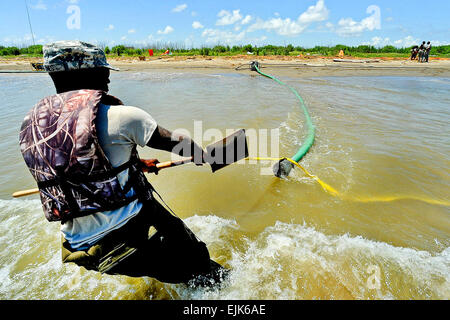 Pvt. Richard Jones bewegt sich das Saugrohr für eine Wasserpumpe, die verwendet wird, um den Tiger Dam Abzweigung Wassersystem nahe dem südwestlichen Pass der Mississippi Fluss-Dreieck, 20. Mai 2010 aufzublasen. Jones' Team baut eine 7.1-Meile-lange Barriere verhindern, dass Öl in den Feuchtgebieten kommen. : Master Sgt. Toby Valadie.   /  / Stockfoto