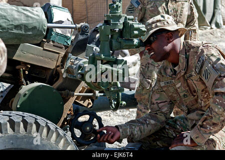 US Army Staff Sgt Jahrahrah Gousby, von Brooklyn, New York, ein Kanonier mit Batterie A, 1. Bataillon, 76. Feldartillerie-Regiment, 4th Infantry Brigade Combat Team, 3. Infanterie-Division, Sehenswürdigkeiten in einer Haubitze 105 mm M119A2 während einer Trockenübung Übung bei Combat Outpost Sultan Kheyl, Provinz Wardak, Afghanistan, 3. Oktober 2013. Die M119A2-Haubitze ist in der Lage, Ziele bis zu 12 Meilen entfernt zu treffen. Da die Batterie, die ein Feuer-Team im September bei Sultan Kheyl ankamen, wurden feindliche Mörser und Raketen Angriffe gegen die COP dramatisch, weitgehend durch das Feuer Team Genauigkeit und schnelle Respons reduziert Stockfoto