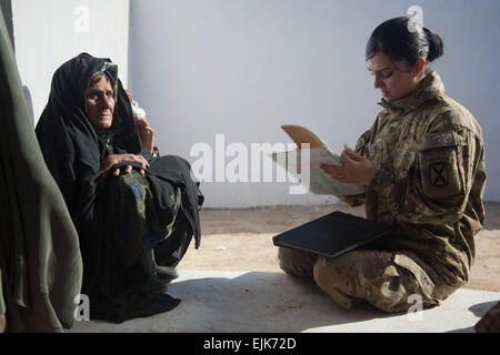 US Armee Sgt. Lidya Admounabdfany schreibt Informationen von einer Frau die Frau Center in der Nähe von Zhari Bezirk Mitte außerhalb der Forward Operating Base Pasab, Provinz Kandahar, Afghanistan, 17. Dezember 2011. Admounabdfany ist ein Mitglied der 3. Brigade, 10th Mountain Division weibliche Engagement-Team und sammelt Informationen von den Frauen der FET decken und Winterkleidung für die Frauen und ihre Familien verteilen kann. Stockfoto