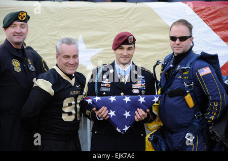 Ehrenmedaille Empfänger SSG Salvatore Giunta, hält die US-Flagge von Navy Fallschirmspringer Jim Woods direkt an das 111. Army Navy Spiel am Lincoln Financial Field in Philadelphia, PA am 11. Dezember 2010 vorgestellt. Ebenfalls gezeigt werden goldene Ritter Fallschirmspringer verließ SFC John Berentis und SGM Stephen Young der goldene Ritter Befehlsgruppe.   SPC James Muir Stockfoto