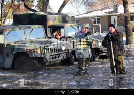 US Army Staff Sgt Robin Mattson spricht mit einem ortsansässigen während Patrouillen in Moorhead, Minnesota, 28. März 2009. Rund 500 Mitglieder der Nationalgarde Minnesota, unter der Leitung von Gouverneur von Minnesota, weiterhin Zivilbehörden zur Unterstützung der Bekämpfung der Flut Bemühungen unterstützen.  Master Sergeant Jason W. Rolfe Stockfoto