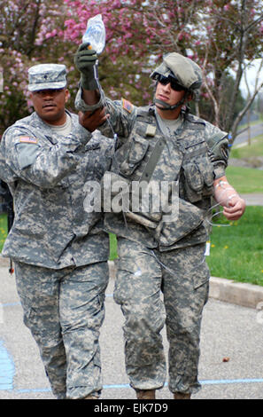 US Army Spc. Peter Bischof unterstützt Sgt. Luis S. Delgadillo, wer Rollenspiel als offene Brust Wunde Opfer, als sie wieder von einer Konvoi-Mission während der Mobilisierung Ausbildung in Fort Dix, New Jersey, 28. April 2007 ist. Bischof und Delgadillo werden sowohl der 302. Mobile Public Affairs Abteilung, Bell, Kalifornien zugewiesen  PFC. Jennifer L. Sierra Stockfoto