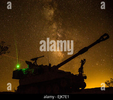 FORT IRWIN, Kalifornien - Soldaten der US Army, zugewiesen Bravo Company, 1. Bataillon, 77th Armor Regiment, 4. gepanzerte Brigade Combat Team, 1. US-Panzerdivision, bieten Sicherheit mit M109A6 Paladin vor einer Aufklärungs-Patrouille während der entscheidenden Aktion Rotation 14-10 im National Training Center hier, 24. September 2014. Entschlossenes Handeln Drehung Training Umwelt Rotationen wurden entwickelt, um ein häufiges Trainingsszenario für den Einsatz der Armee und der Koalitionstruppen zu erstellen.   Sgt. Richard W. Jones Jr., Betriebsgruppe, National Training Center Stockfoto