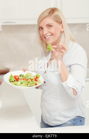 Frau kocht Salat in der Küche Stockfoto