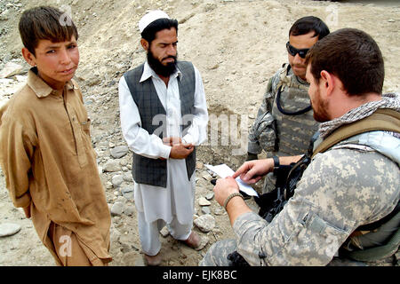 US Army Staff Sgt Artez Briseno, Recht, spricht mit Mohammad Eqbal, Mitte links, Gar Sagi Dorfälteste, über Behandlung für Ashqmana Gulab, links, 29. Oktober 2009, in der Provinz Kunar, Afghanistan. Ashqmana aufheben seinen rechten Arm nicht mehr als sechs Zoll, weil eine verrückte Schulter bei einem Sturz nicht richtig zu heilen. Briseno hat eine erste Einschätzung des jungen und gab dem älteren eine Autorisierung.  Techn. Sgt. Brian Boisvert Stockfoto