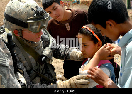 Ein US-Soldat untersucht ein irakisches Mädchen auf eine medizinische Mission in Balad, der Irak, 2. Juni 2009. Das 532nd Expeditionary Sicherheit Kräfte Geschwader ist verantwortlich für die Sicherheit rund um Joint Base Balad und weiterhin ein aufgebautes Verhältnis zu der Bevölkerung der Dörfer und Bauernhöfe.  Kapitän Michael R. Vincent Stockfoto