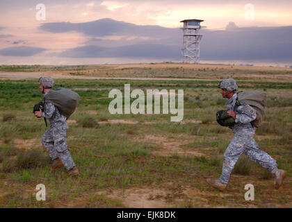 Sgt. Kris Hillebrand von Firma B, 1. Bataillon, 508. Fallschirm-Infanterie-Regiment, 4th Brigade Combat Team, 82nd Airborne Division, links, und Sergeant Carlos Garcia von Unternehmen E, 782nd Brigade Support Battalion, 4. BCT, 82. Abn. Div., weglaufen Holland Drop-Zone 5 Mai am Fort Bragg nach erfolgreichem Abschluss einen Static-Line Sprung von einer Galaxie c-17-Flugzeuge. Die Fallschirmjäger waren Luft Kenntnisse Ausbildung, um ihre Fähigkeiten scharf zu halten, bevor die Bereitstellung in Afghanistan noch in diesem Sommer dirigieren.  Sgt. Stephen Decatur Stockfoto