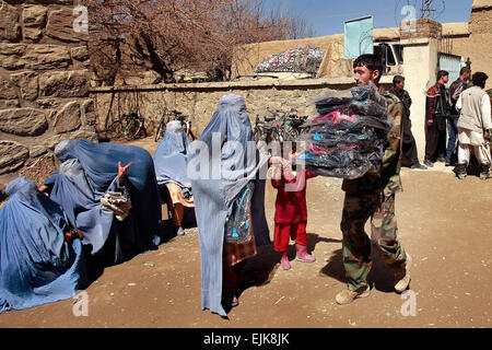 Eine afghanische Nationalarmee Kommando aus der 6. Kandak Hände Schultaschen für Frauen und Kinder während einer humanitären Hilfsmission 25. März 2009, an einer Schule in Kabul, Afghanistan.  Staff Sgt Russell Klika, US-Armee Stockfoto