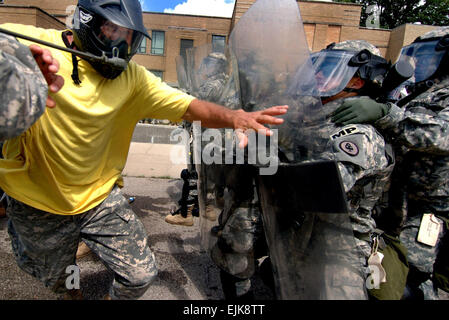 Ein Instruktor Rollenspiel als ein Randalierer Belastungen über die Grundlinie der US-Armeesoldaten aus der 130. Military Police Company, Tennessee Army National Guard in Ausbildung bei der Muscatatuck Urban Training Center, ind., 25. August 2007. Die Soldaten sind Schulungen für eine baldige Entsendung in den Kosovo.  SPC. Jerome Bischof Stockfoto