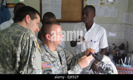 Colonel Mark Burnett, Arzt für Allgemeine Pädiatrie, pädiatrische Infektionskrankheiten und Tropenmedizin Arzt aus Tripler Army Medical Center in Honolulu, erhält eine Demonstration auf Infektionskrankheiten Erkennung und Behandlung von Benin bewaffnete Kraft während medizinische Bereitschaft Übung 13-1 in Contonou, Benin, Jan. 14-25.  USA und Benin durchgeführt die MEDRETE für militärische medizinische Fachkreise zu Aufbau und die Stärkung der Kapazitäten im Bereich der öffentlichen Gesundheit durch die Stärkung der Fähigkeit zu führen für die Überwachung, Verhütung und Bewältigung Infektionskrankheiten, einschließlich Ausbrüche, Bioterrorismus und ot Stockfoto