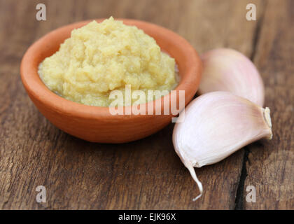 Gemahlener Ingwer mit Knoblauch auf Holzuntergrund Stockfoto