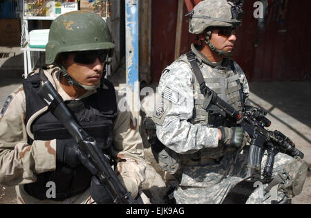 US Army Staff Sgt Antonio Alvarado Bravo Batterie, 2nd Battalion, 319th Airborne Field Artillery Regiment sichert neben einem irakischen Soldaten aus 4. Kämpfer-Kompanie in der Adhamiya Distrikt, Bagdad, Irak, 10. August 2007.  Sgt. Jeffrey Alexander veröffentlicht Stockfoto