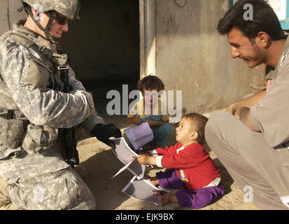 US Army 1st Lt. Michael Miller, Delta Gesellschaft, 27. Kavallerie-Regiment, 4th Brigade Combat Team, 1. Kavallerie-Division, irakische Kinder zeigt, wie man seine Feder bei Eingriffen am Stadtrand von Mosul, Irak, 17. September 2007 verwenden.  Flieger 1. Klasse Christopher Hubenthal Stockfoto