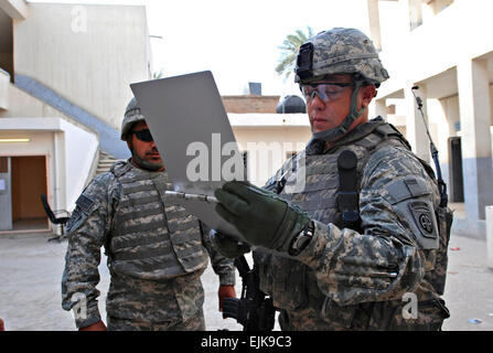 070909-A-5406P-001. JPG-Fayetteville, NC-Native 1st Lt. Larry Pitts, Kommandant der B Batterie, 2nd Battalion, 319th Airborne Field Artillery Regiment, prüft eine Fremdfirma Rekordbücher beim Überprüfen des Fortschritts auf ein Schulprojekt für die Renovierung im Stadtteil Graya'at von Bagdads Adhamiyah Bezirk Sept. 7.  Sgt. Mike Pryor, 2. BCT 82. Abn. Div. Öffentlichkeitsarbeit Stockfoto