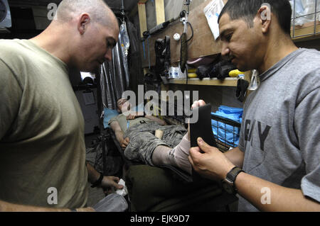 US Armee Generalmajor David Hernandez, links, und Sgt. Gary N. Orvise stabilisieren Pfc. Brian Pruette gebrochenen Knöchel während einer Patrouille der demontierten Präsenz in Bagdad, Irak, 23. Juni 2007. Orvise ist vom 2. Bataillon, 15. Feld-Artillerie-Regiment, 2nd Brigade Combat Team aus Fort-Trommel, N.Y.  Master Sergeant Jonathan Doti Stockfoto