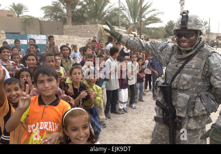 US Armee Sgt. Franklin Bangura Wellen an irakische Kinder während der Eröffnung der neuen Schule in Lutafiyah, Irak, 1. Oktober 2007.  Bangura ist Bravo Batterie, 2. Bataillon, 15. Feld-Artillerie-Regiment, 2nd Brigade Combat Team, 10. Mountain Division Light Infantry zugeordnet.   Staff Sgt Quinton Russ Stockfoto