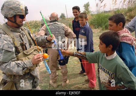 US Army 1st Lt. Peters vom 1. Bataillon, 8. Marine Regiment, II Marine Expeditionary Force, Civil Affairs Group, lehrt irakische Kinder wie eine Angelrute in Ramadi, Irak, 20. Oktober 2007 benutzen.  SPC. Kieran Cuddihy veröffentlicht Stockfoto