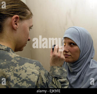 US Armee Sgt. Carrie Coble untersucht eine irakische Frau Augen in Hateen, Irak, 7. Juli 2007. Entgeisterung ist von Charlie Kompanie, 299. Forward Support Battalion, 2nd Brigade Combat Team, 1st Infantry Division.  Flieger 1. Klasse Stephanie Longoria veröffentlicht Stockfoto