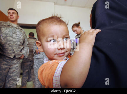 Ein wenig irakischen Jungen lächelt als er mit seiner Mutter sitzt und wartet darauf, von einem US-Army Medic von Charlie Kompanie 203. Medical Support Battalion und 3. Staffel zu sehen, 1. Kavallerie-Regiment, 3. Brigade, 3. US-Infanteriedivision während einer medizinischen bürgerschaftliches Engagement programmieren an der medizinischen Klinik in Narhwan, Irak, 8. Oktober 2007.   Sgt. Timothy Kingston Stockfoto